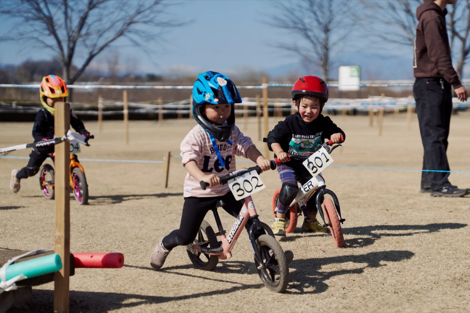 ゼッケンをつけてキックバイクで競り合うキッズ